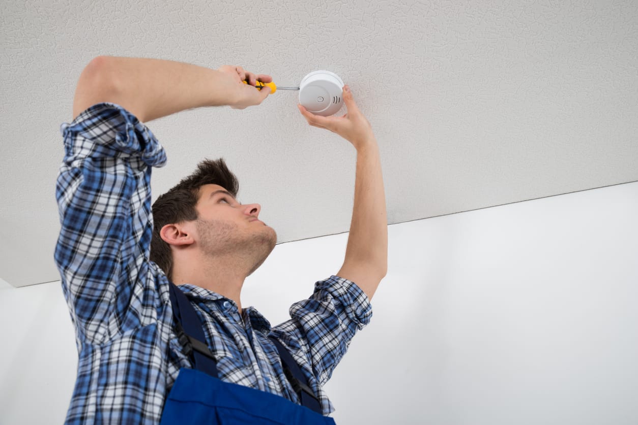 Electrician Repairing Fire Sensor